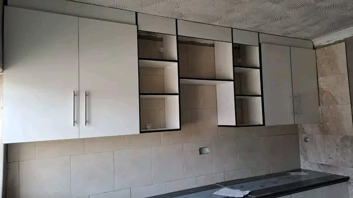 Modern L‑shaped kitchen with wood and stone finishes